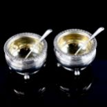 A pair of George III silver salt cellars, bulbous circular form with gadrooned rim, bun feet and