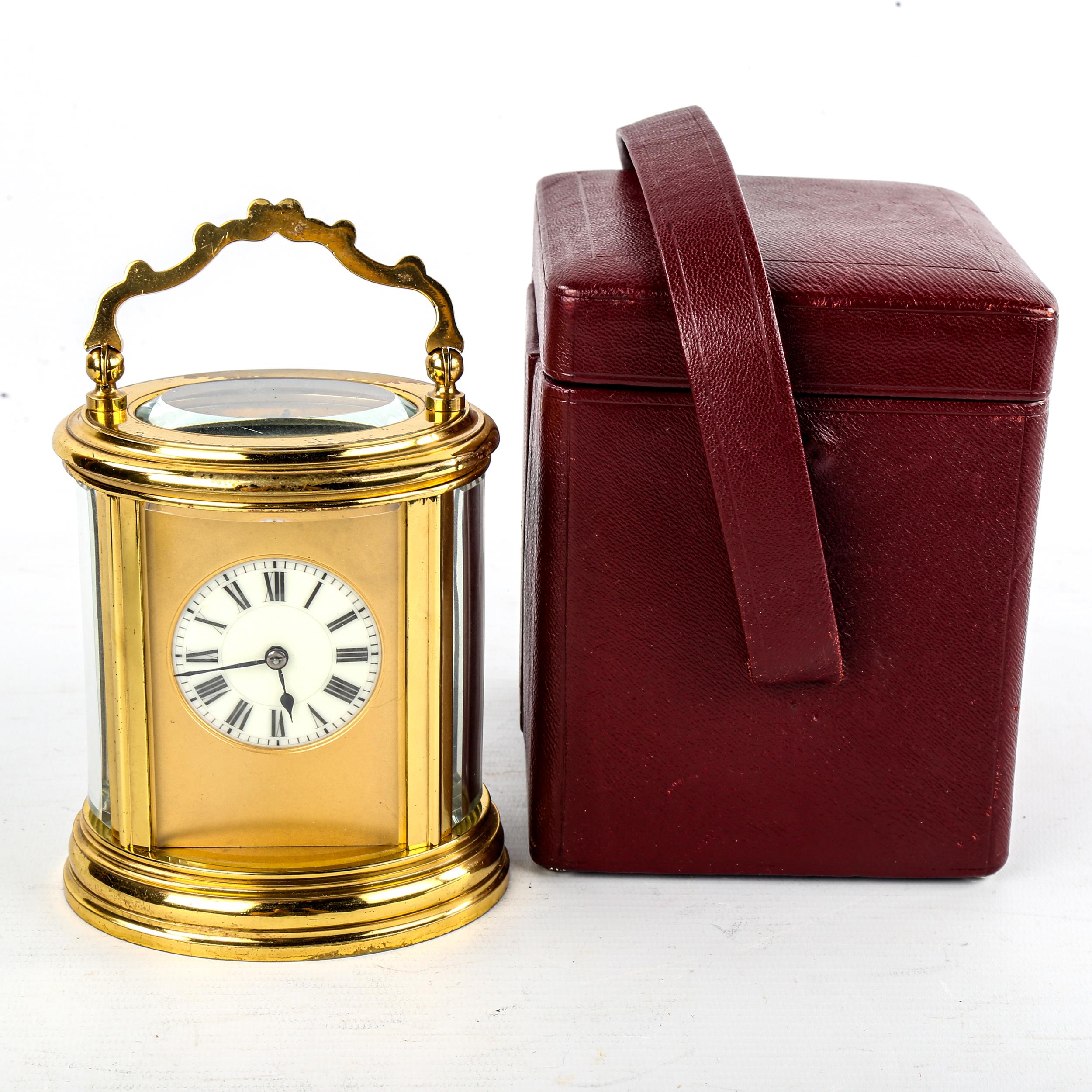 A French oval brass-cased chiming carriage clock, white enamel dial with Roman numeral hour markers,