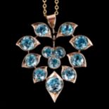 A Middle Eastern blue zircon floral pendant necklace, unmarked yellow metal settings with round