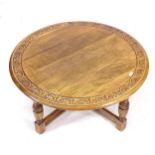 A circular oak coffee table, with carved edge and cross stretchers, W101cm, H46cm
