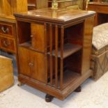 An Edwardian mahogany and marquetry decorated revolving bookcase, with open shelves and cupboard