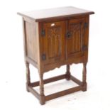 A small oak side cabinet, with 2 carved panelled doors, on baluster legs, W51cm, H68cm, D33cm