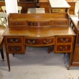 An Edwardian mahogany and satinwood-banded bow-front writing desk, with fitted drawers, W122cm,