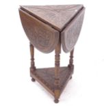 An oak drop leaf cricket table, with allover relief carved decoration, W57cm, H75cm