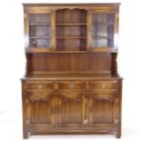 An oak dresser with glazed cupboard top, 3 frieze drawers and fielded panelled cupboards under,