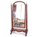 A large Victorian mahogany arch-top cheval mirror, with serpentine-shaped base, and scrolled legs,