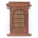 An ornate Indian hardwood and brass decorated window, with allover relief carved decoration,