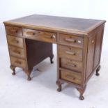 An early 20th century oak kneehole writing desk, with 9 short drawers, W107cm, H74cm, D61cm,
