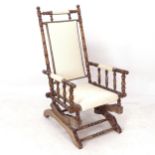 A Vintage American stained beech rocking chair, with cream upholstery