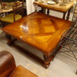 A large cherrywood effect square coffee table, with a parquetry top, on baluster turned legs,