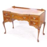 A 1930s crossbanded bow-front writing desk, with 3 short drawers, on cabriole legs, W111cm, H74cm,