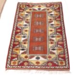 A red ground Afghan design rug, 192cm x 131cm