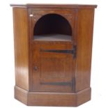 A Liberty's oak corner cupboard, with open arch-top and panelled door, on plinth base, label to