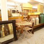 A painted wrought-iron circular folding garden table, and a pair of matching folding chairs