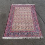 A red ground Persian design carpet, with a symmetrical multiple border and rectangular lozenge,