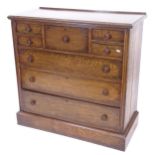 A 1920s oak chest, with central hat drawer, 4 short and 3 long drawers, on plinth base, W107cm,