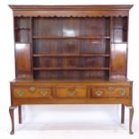 An Antique oak Welsh dresser, with a boarded open plate rack and crossbanded cupboards, 3 frieze