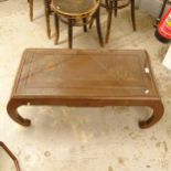 A Chinese hardwood opium table, with relief carved decoration, glass inset top, on scrolled legs,