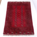 A red ground Afghan design rug, with symmetrical border and gul lozenge, 182cm x 130cm