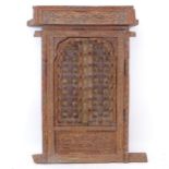 An ornate Indian hardwood and bras-mounted window, with allover relief carved decoration, W62cm,