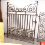 A large pair of decorative scrolled wrought-iron drive gates, width not including hinged mounts