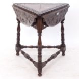 A Victorian carved oak drop leaf cricket table, on baluster turned legs