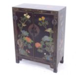 A Chinese black lacquered side cabinet, with 2 panel doors, and allover gilded and floral