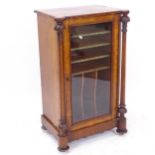A Victorian walnut and satinwood-strung music cabinet, with single glazed door and carved and fluted