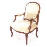 A French carved beech-framed and upholstered open arm chair, with cabriole legs