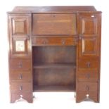 A 1920s oak student's bureau, with panelled cupboards, drawers and open shelves, W106cm, H114cm