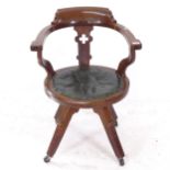 An Arts and Crafts oak bow-arm swivel desk chair