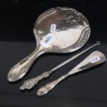 A silver-backed dressing table mirror, a silver-handled button hook, and glove stretcher (3)