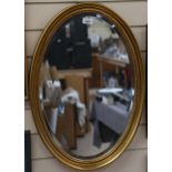 A giltwood-framed oval bevel-edge wall mirror, 65cm