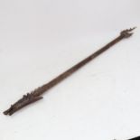 An Oriental carved wood blowpipe, length 86cm
