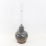 An Art pottery oil lamp, signed, height 43cm