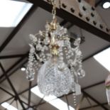 A gilt-metal chandelier, with swags of lustre drops and cut-glass light bowl, 26cm across