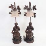 A pair of bronzed resin figural table lamps, with pink glass floral shades, overall height 56cm
