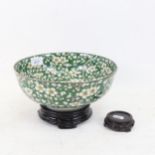 An Oriental green ground porcelain bowl, with prunus decoration, and 2 stands, bowl 24cm diameter