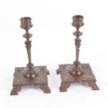 A pair of Arts and Crafts Max Hartmann copper alloy table candlesticks, pierced and engraved