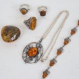 A tray containing 3 silver and amber mounted rings, an amber and silver bracelet, pendant etc