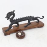 A Chinese black painted cast-iron dragon figure, on fitted stand, dragon length 32cm