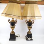 A pair of black and gold urn design table lamps, with matching shades, height 88cm overall