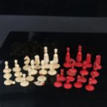 A 19th century Indian part chess set, red stained and white carved ivory pieces, King height 6.