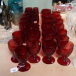A suite of moulded ruby glassware, including tumblers, goblets and Champagne flutes