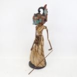 An Eastern carved and painted wood puppet, mounted on plinth, 60cm overall