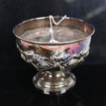 An Edward VII silver bowl on foot, with stylised embossed decoration, engraved 1927-July 6th-1952,