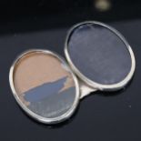 A silver double-oval photograph frame, with silver strut