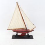 A Vintage Tri-ang painted tin pond yacht, height 39cm, on display stand