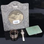 An embossed arch-top silver-fronted photo frame, a silver napkin ring, a silver and shagreen card