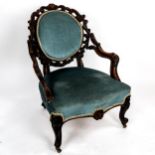 A Victorian walnut-framed fireside chair, with elaborate carved and pierced surround